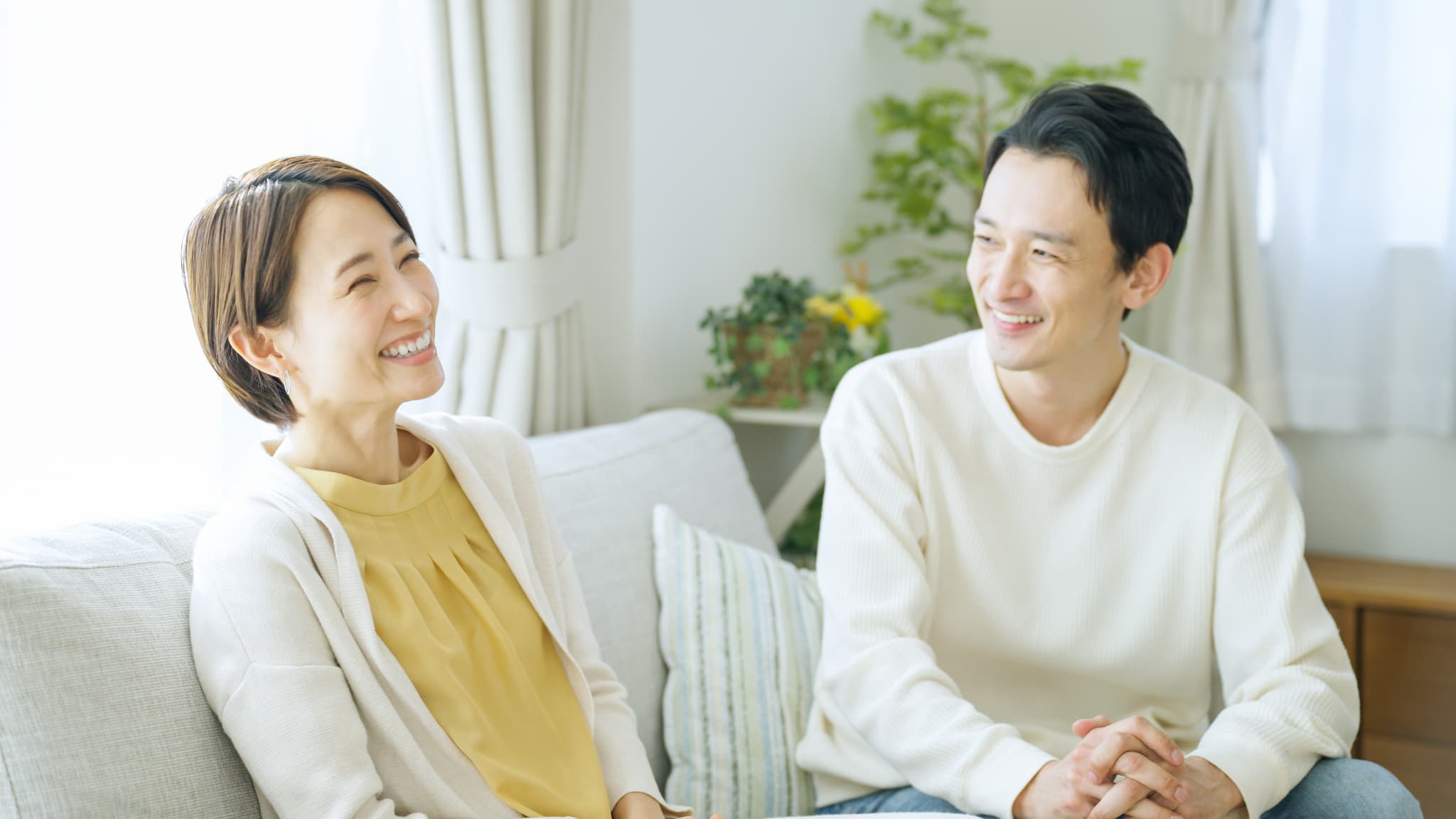 リビングで会話するリラックスした表情の夫婦