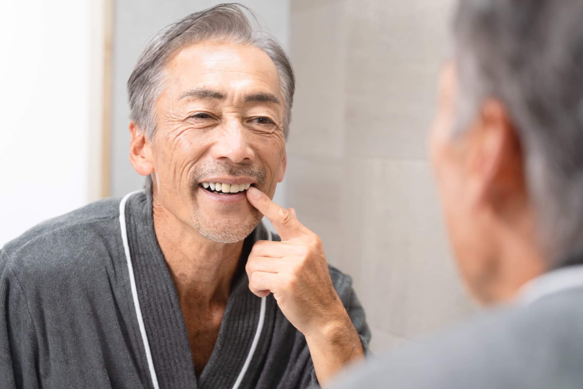 入れ歯を確認する笑顔の高齢男性