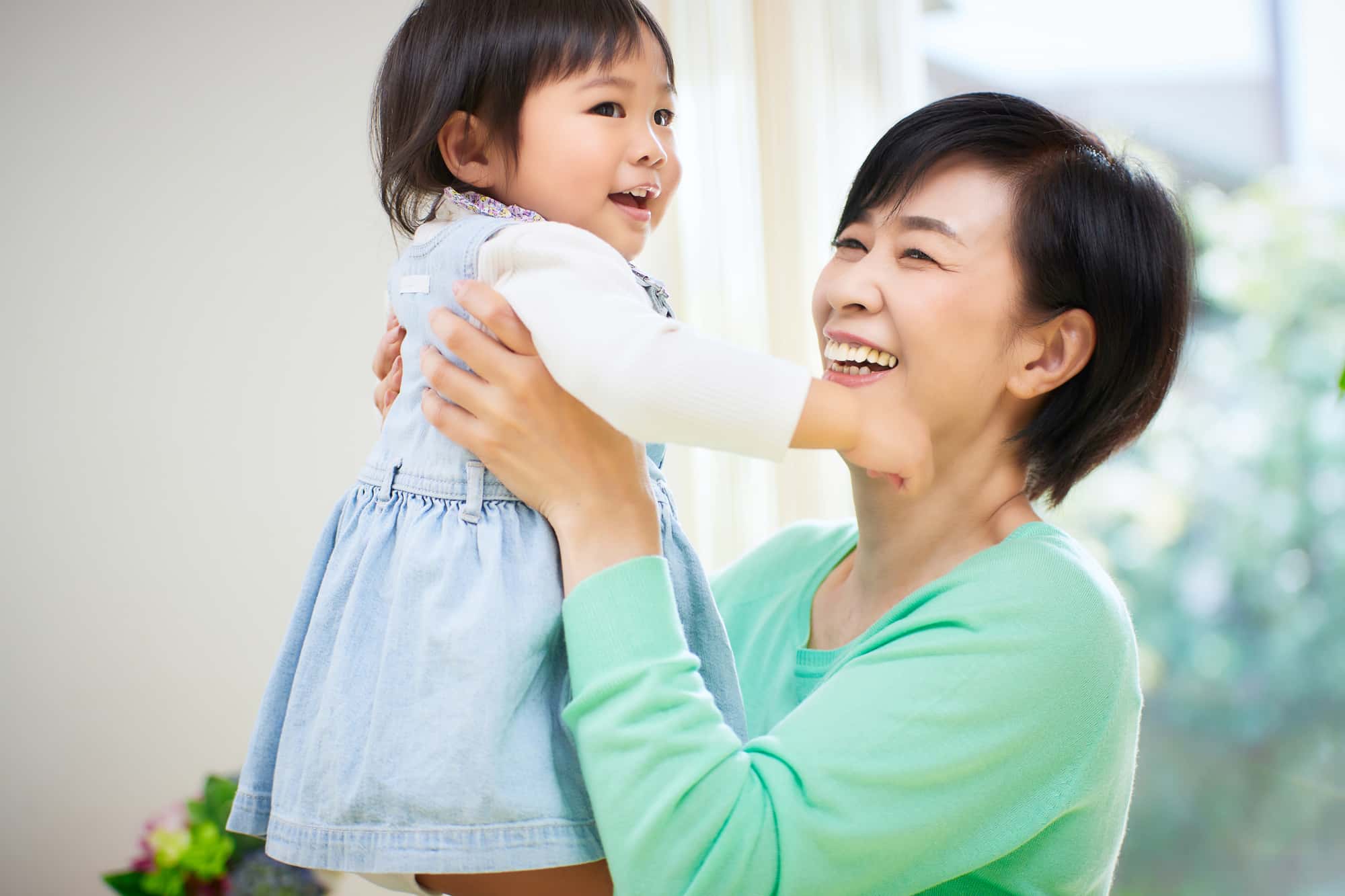 適切なケアでインプラント周囲炎を予防した女性が孫と遊んでいるイメージ