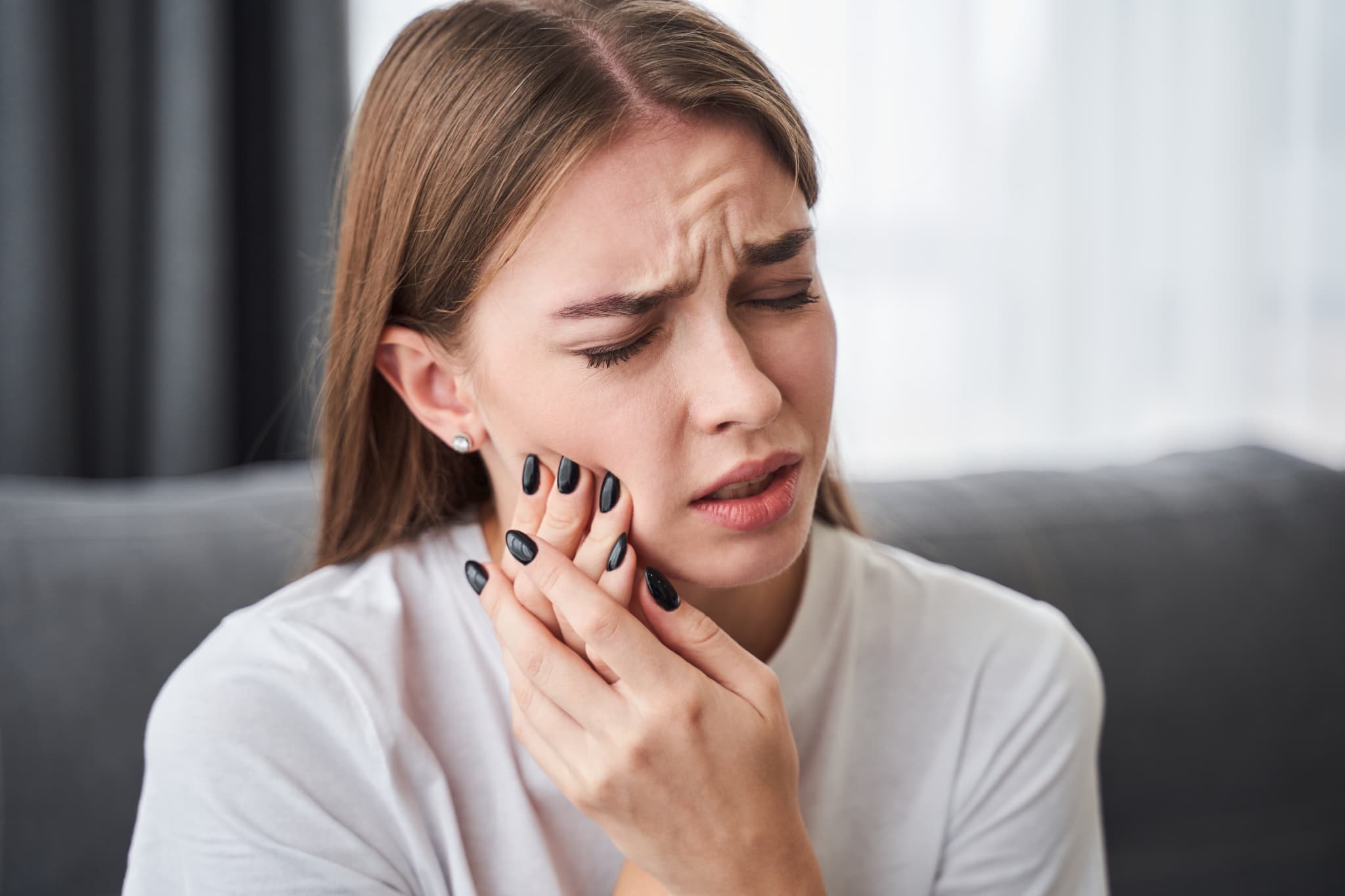 歯の矯正中に痛みを感じる女性