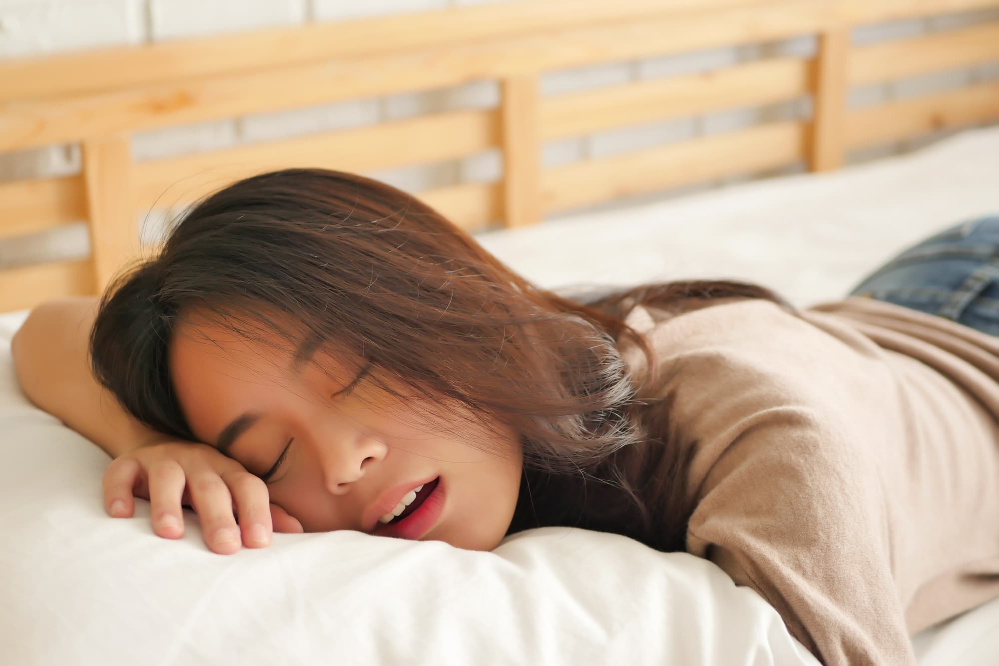 口呼吸をしながらうつ伏せで眠る女性